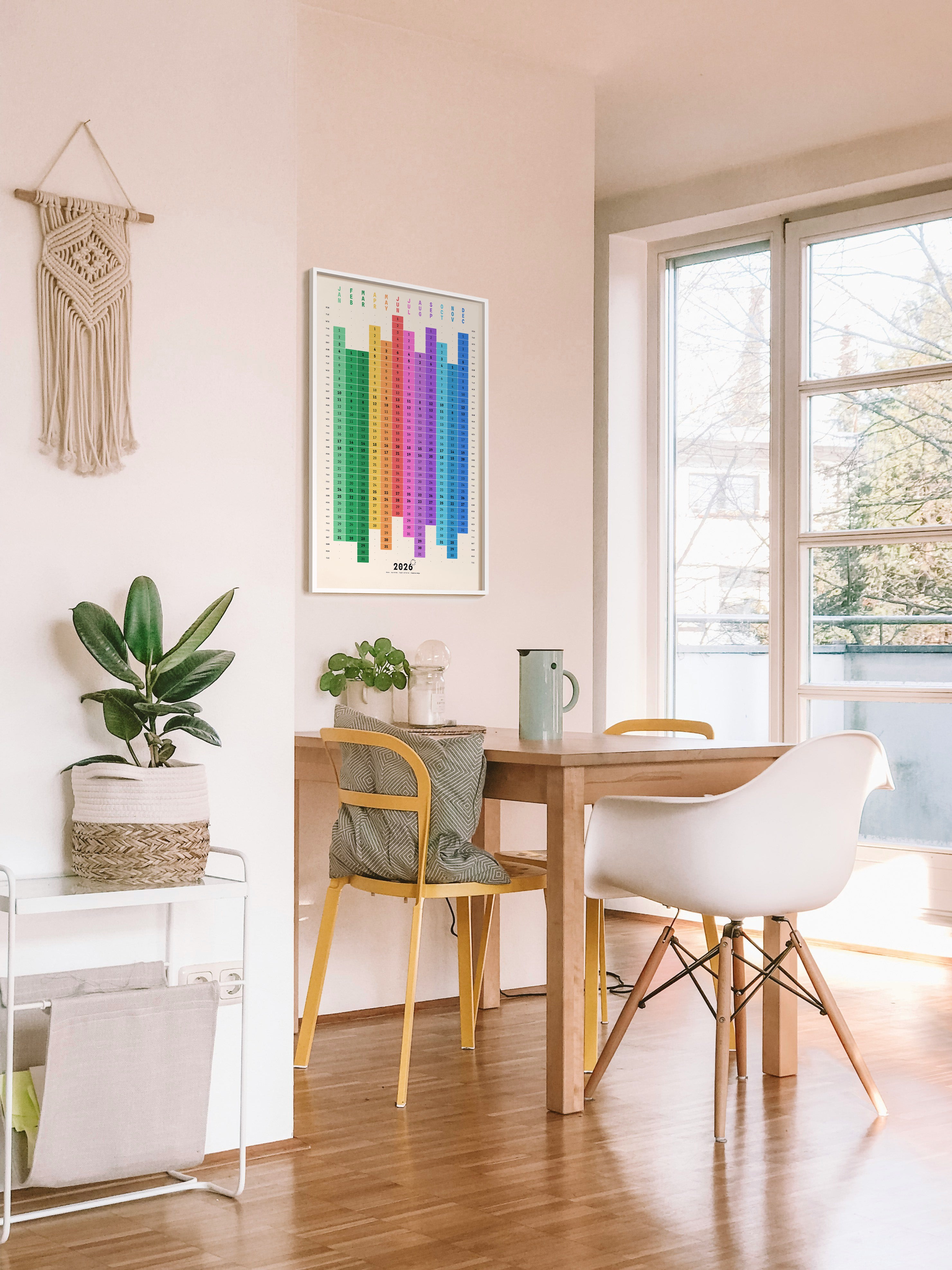 Modern home office with a desk, chairs, and decorative elements. Framed wall calendar above the dining table.