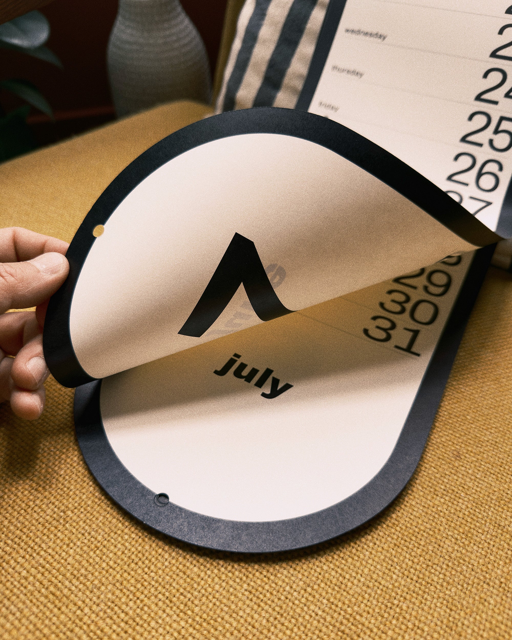 Calendar page with July being pulled out on a textured surface
