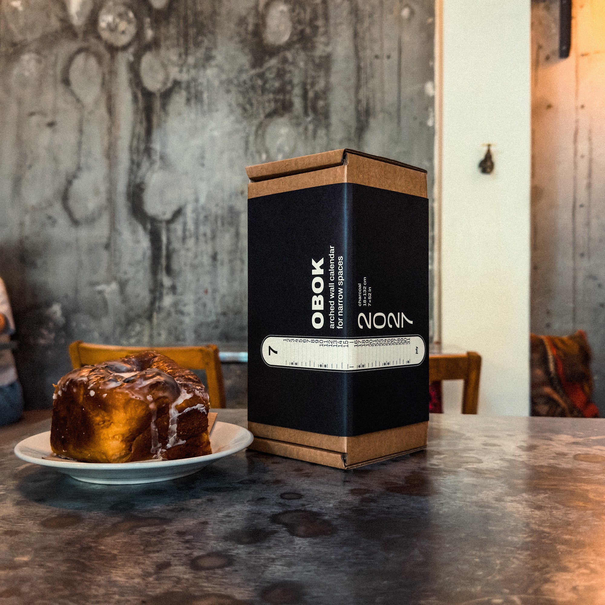 Obok packaging with a cinnamon roll on a rustic table