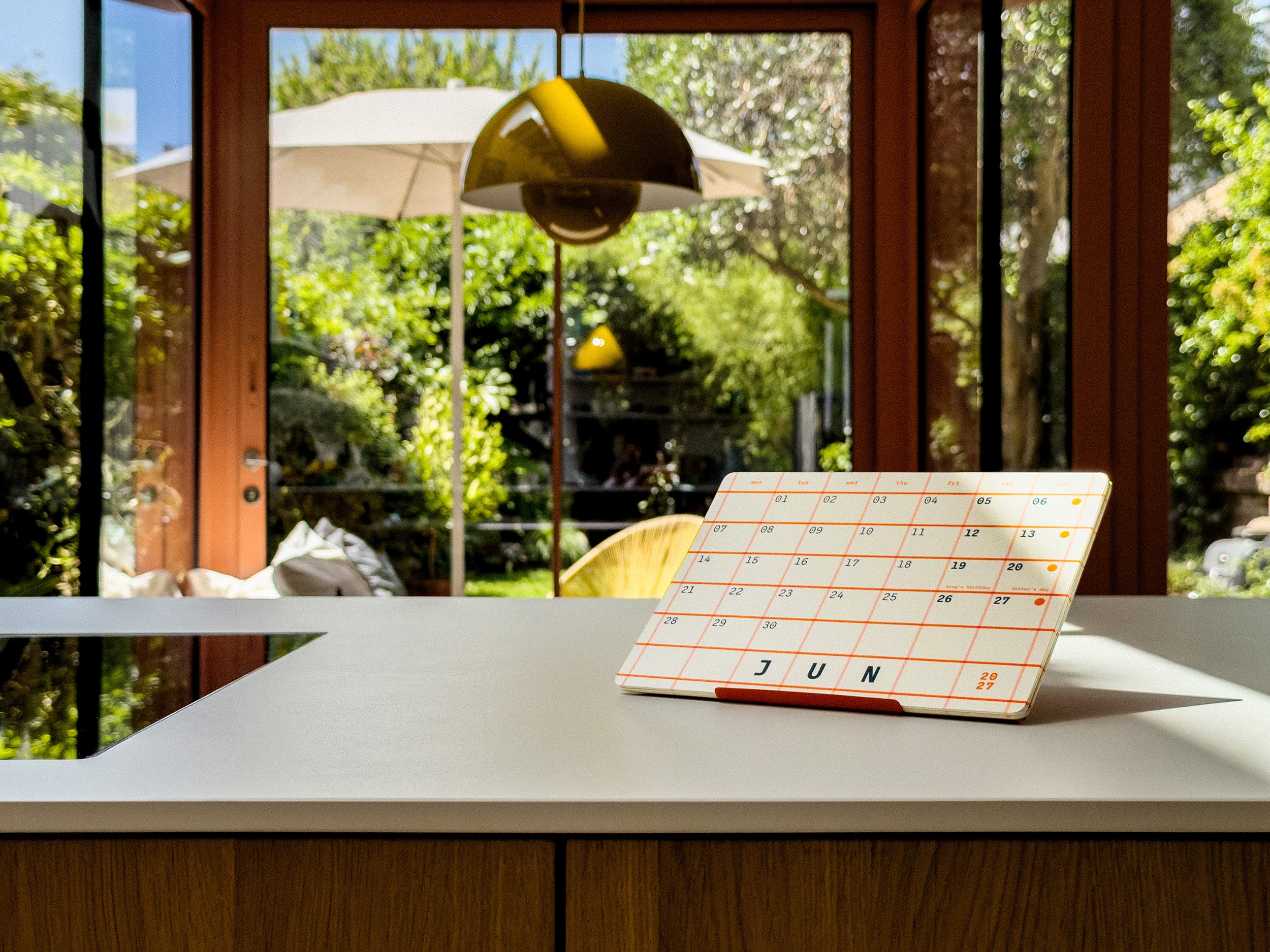 Calendar on a table with a window view of greenery